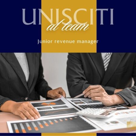 Due persone in abiti formali sedute a una scrivania esaminano documenti e grafici, con una calcolatrice sul tavolo; sullo sfondo si vede un logo blu e giallo con la scritta Unisciti al team e la dicitura Junior revenue manager.